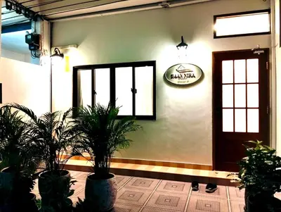 a room with potted plants and a sign on the wall at Baannira บ้านนิรา in Ban Sam Kong