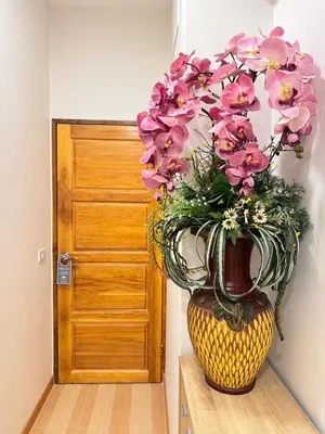 a vase filled with pink flowers sitting in front of a door at Baannira บ้านนิรา in Ban Sam Kong