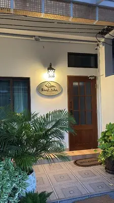 a sign on the side of a building with a door at Baannira บ้านนิรา in Ban Sam Kong