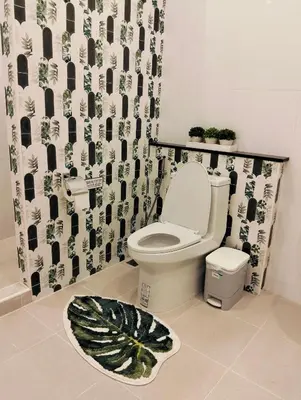 a bathroom with a toilet and a plant rug at Baannira บ้านนิรา in Ban Sam Kong