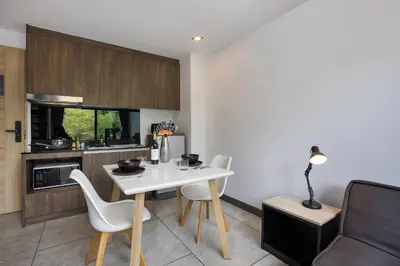 a kitchen with a white table and white chairs at Duplex in NaiHarn Residence near the Beach, UTL B325 in Rawai Beach