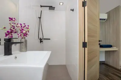 a white bathroom with a sink and a shower at Duplex in NaiHarn Residence near the Beach, UTL B325 in Rawai Beach