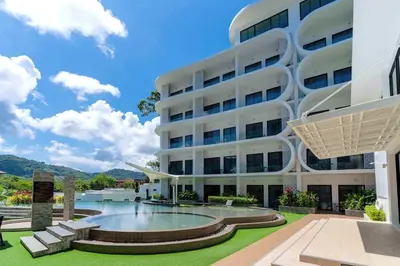 a large white building with a pool in front of it at Duplex in NaiHarn Residence near the Beach, UTL B325 in Rawai Beach