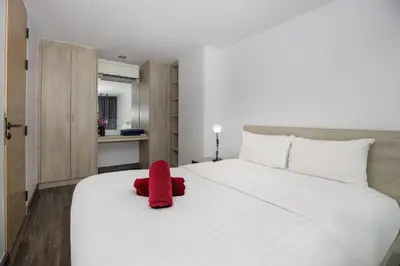 a red stuffed animal sitting on top of a white bed at Duplex in NaiHarn Residence near the Beach, UTL B325 in Rawai Beach