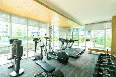 a gym with treadmills and ellipticals in a room with windows at Tony DCondo in Kathu