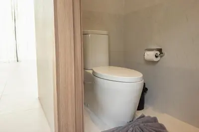 a bathroom with a toilet and a roll of toilet paper at Mouana Breeze Maikhao VIP 4-bedroom Pool Villa 9915 in Mai Khao Beach