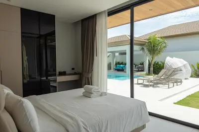 a bedroom with a white bed and a large window at Mouana Breeze Maikhao VIP 4-bedroom Pool Villa 9915 in Mai Khao Beach