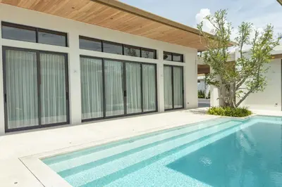 a swimming pool in front of a house at Mouana Breeze Maikhao VIP 4-bedroom Pool Villa 9915 in Mai Khao Beach