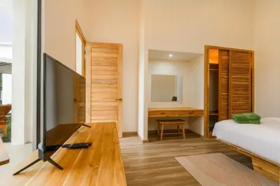 a bedroom with a television and a bed and a desk at Dutch Villas Phuket in Koh Lone