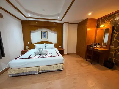 a bedroom with a bed and a desk and a sink at Beach Comber in Patong Beach