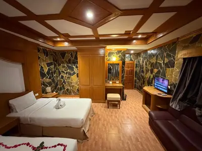 a hotel room with two beds and a television at Beach Comber in Patong Beach