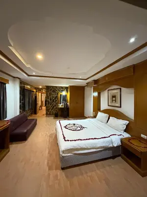 a bedroom with a large bed and a living room at Beach Comber in Patong Beach