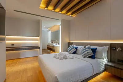 a bedroom with a large white bed with blue pillows at Layana Residence in Layan Beach