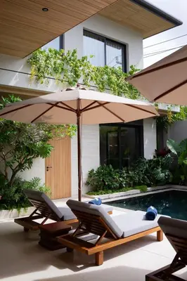 two lounge chairs and an umbrella next to a pool at Layana Residence in Layan Beach