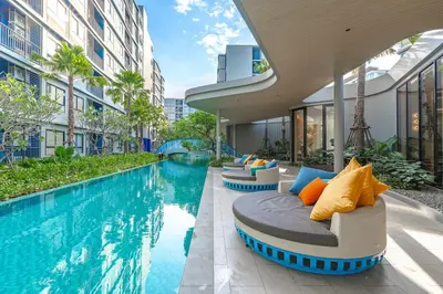 a swimming pool with lounge chairs next to a building at C175 Stylish Condo with Pool View D Condo Phuket in Kathu