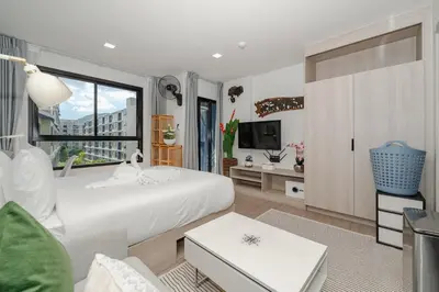 a bedroom with a white bed and a large window at C175 Stylish Condo with Pool View D Condo Phuket in Kathu
