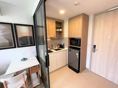 a small kitchen with a table and a refrigerator at Apartment at Skypark Laguna next to golf course in Bang Tao Beach
