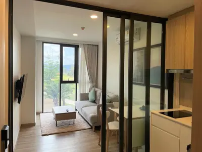 a living room with a couch and a table at Apartment at Skypark Laguna next to golf course in Bang Tao Beach