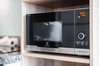 a microwave oven on a shelf in a kitchen at C176 Diamond Paradise Getaway Condo Phuket in Bang Tao Beach