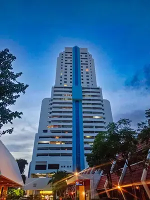 a tall blue and white building at night at Patong Tower in Patong Beach