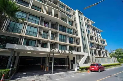 a building with a red car parked in front of it at Top Floor Condo Mountainview, 5min to beach, Bangtao Phuket in Bang Tao Beach