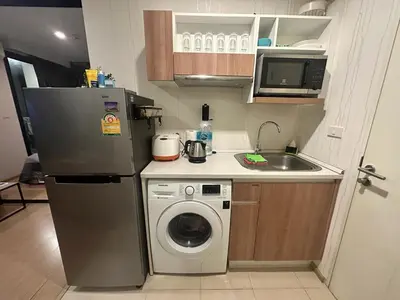 a kitchen with a refrigerator and a washing machine at Top Floor Condo Mountainview, 5min to beach, Bangtao Phuket in Bang Tao Beach
