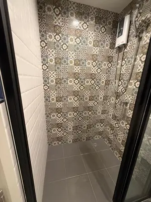 a bathroom with a shower with a tile wall at The Base Central Phuket-B20W in Ban Rangeng
