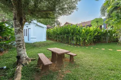 a bench sitting next to a tree in a yard at V269 Yamu Sunset Villa 3BR Sea View Pool Retreat in Ban Bang La