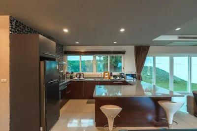a kitchen with a large island with a counter top at V269 Yamu Sunset Villa 3BR Sea View Pool Retreat in Ban Bang La