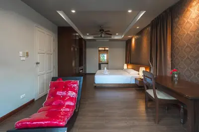 a bedroom with a bed and a red couch at V269 Yamu Sunset Villa 3BR Sea View Pool Retreat in Ban Bang La