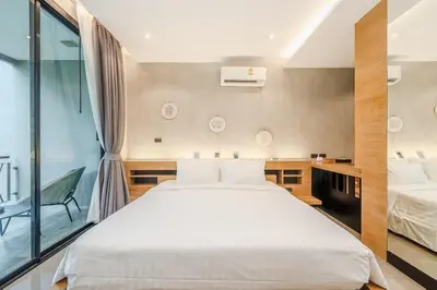 a bedroom with a large white bed and a window at C179 Serene and Stylish Getaway in Kamala, Phuket in Kamala Beach