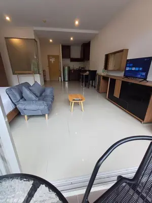 a living room with a blue couch and a table at Chic Condominium in Karon Beach