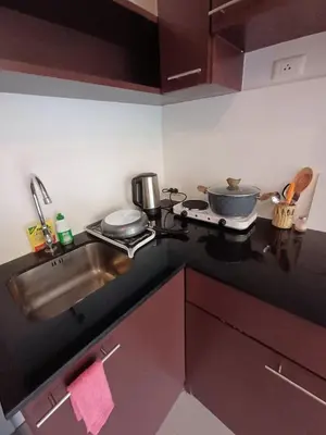 a kitchen counter top with a sink and a stove at Chic Condominium in Karon Beach