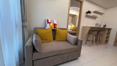 a couch with pillows on it in a living room at Fantasea Kamala Beach 1 BR 313 in Kamala Beach