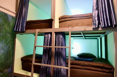 two bunk beds in a room with a mirror at The City Hostel in Phi Phi Don