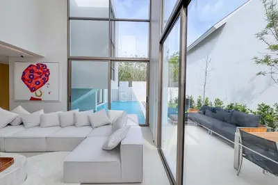 a living room with a white couch and a pool at Designer 3BR Pool Villa in New Build LuxPride 4 L8 Residence in Bang Tao Beach
