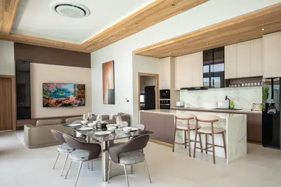 a dining room and kitchen with a table and chairs at Mouana Breeze Maikhao VIP 4-bedroom Pool Villa 9916 in Mai Khao Beach