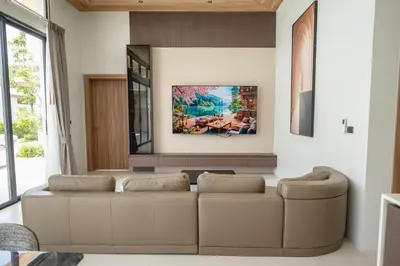 a living room with a couch and a painting on the wall at Mouana Breeze Maikhao VIP 4-bedroom Pool Villa 9916 in Mai Khao Beach