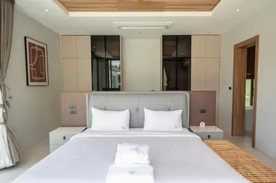 a bedroom with a large white bed with two pillows at Mouana Breeze Maikhao VIP 4-bedroom Pool Villa 9916 in Mai Khao Beach