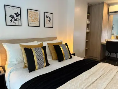 a bedroom with a large bed with black and yellow pillows at C181 Stylish 1BR Loft Near Naiharn Beach Pool Gym in Rawai Beach