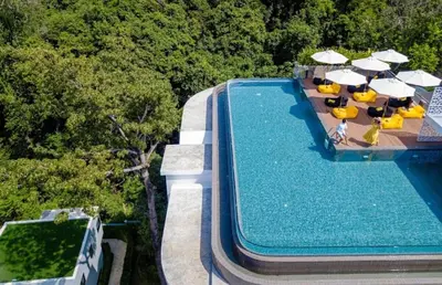 an overhead view of a swimming pool with chairs and umbrellas at C181 Stylish 1BR Loft Near Naiharn Beach Pool Gym in Rawai Beach
