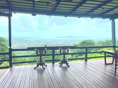 a wooden deck with a table and chairs on it at The house on the hill in Ban Na Kok