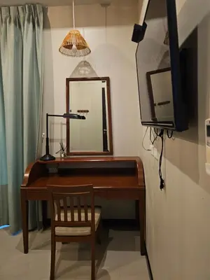 a desk with a mirror and a chair in a room at The house on the hill in Ban Na Kok