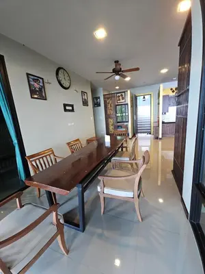 a dining room with a table and chairs and a clock at The house on the hill in Ban Na Kok