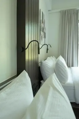 two beds in a hotel room with white pillows at Green Garden Villa Hotel in Nai Harn Beach