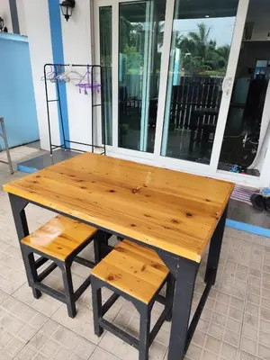 a wooden table with a bench and two chairs at Maison local avec terrasse et cuisine extérieure Proche Patong in Kathu
