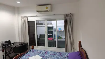 a bedroom with a bed and a desk and a window at Maison local avec terrasse et cuisine extérieure Proche Patong in Kathu