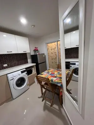 a kitchen with a table and a washing machine at Plus 1 Condo 202-67 in Kathu