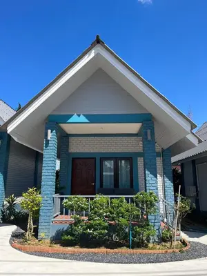 a blue brick house with a brown door at J&B House in Nai Yang Beach