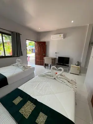 a hotel room with two beds and a television at J&B House in Nai Yang Beach